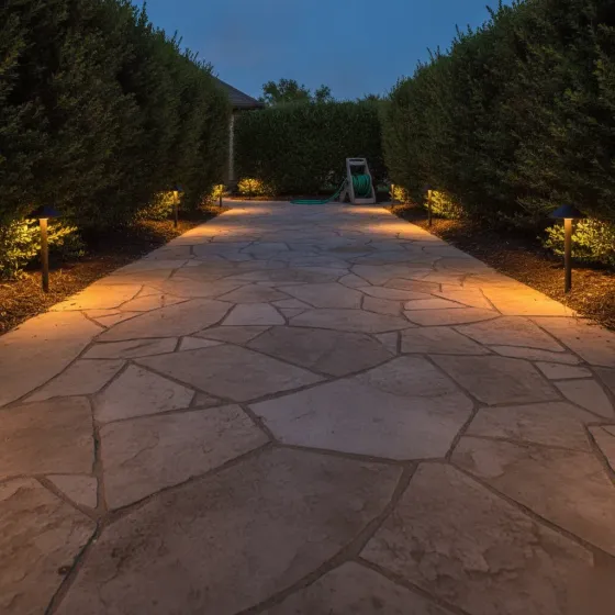 outdoor-lighting-installation-pathway-result-denton Finished pathway lighting installation glowing along stone walkway in Denton yard